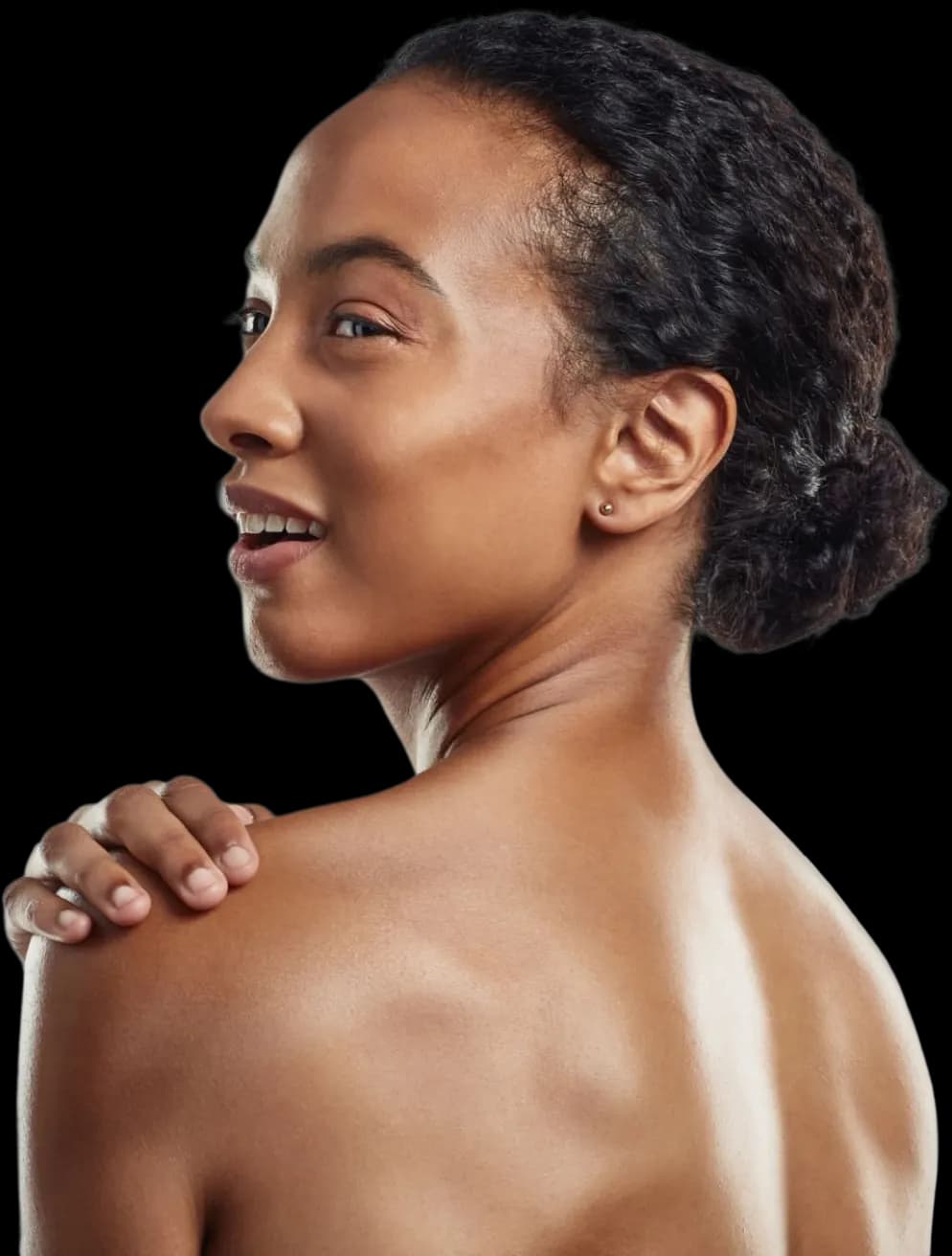 Woman looking back over her shoulder, hand resting on her skin