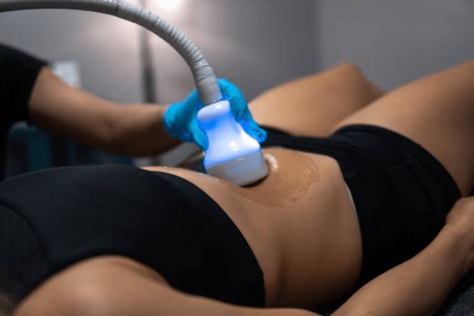 Gloved hand using a lighted contouring device on the abdomen