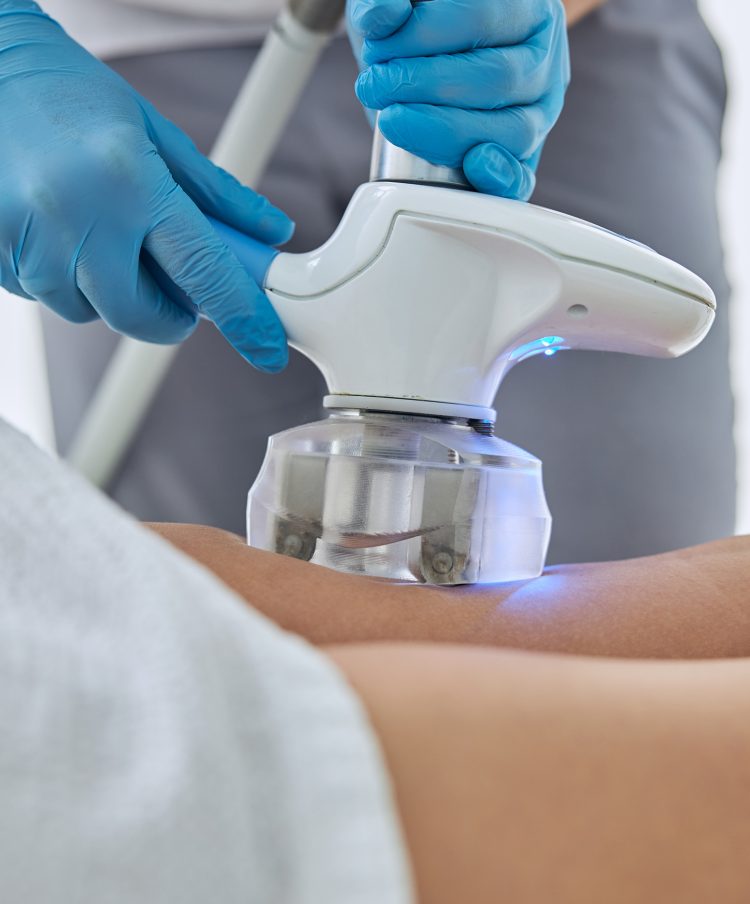 Cropped head portrait of beautician doing ultrasound cavitation body contouring treatment in wellness spa center